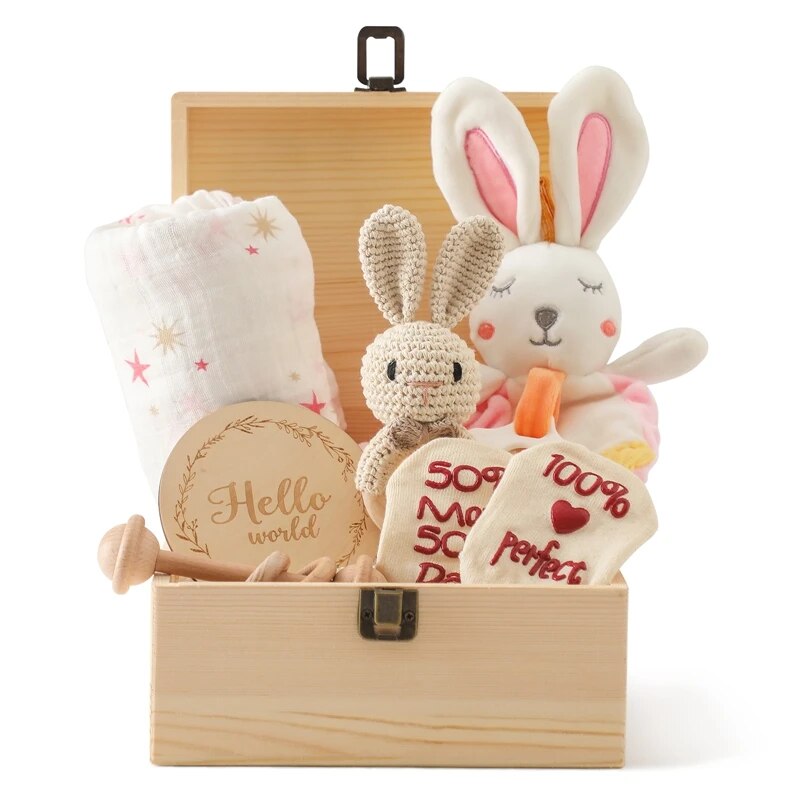 Das Anna Baby Geschenk zur Geburt von Hello World ist eine bezaubernde Geschenkbox aus Holz, gefüllt mit einem Plüschhasen, einem gehäkelten Hasen, einer Sternendecke, einem "Hello World"-Schild, beigen Socken mit rotem Text und Holzspielzeug - perfekt für neue Familien.