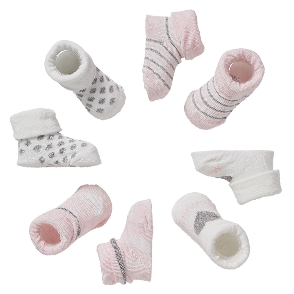 Diverses chaussettes bébé en rose et blanc avec détails argentés disposées individuellement