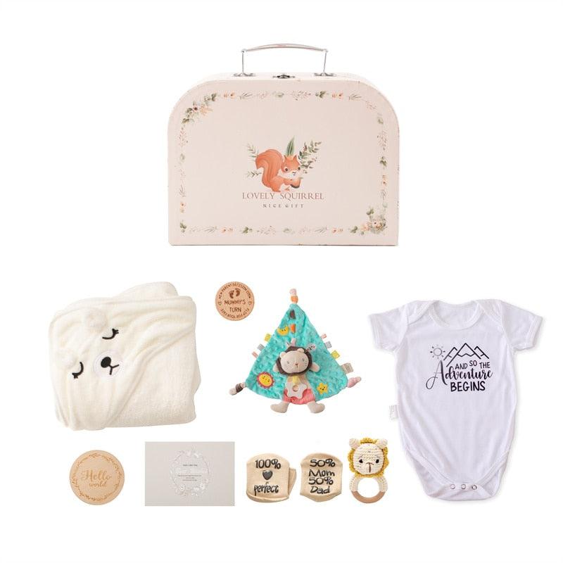 Das Fiodor Baby Geschenk zur Geburt von Hello World enthält einen cremefarbenen Koffer mit Eichhörnchenmotiv, eine weiße Bärendecke, einen Abenteuer-Body, eine Löwenrassel, ein Beißspielzeug und hölzerne Meilensteinkarten - ideal als Baby-Erstausstattung.