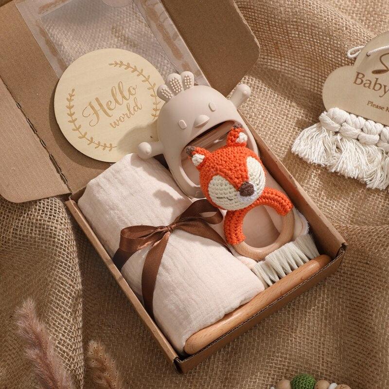 Das Foxy Baby Geschenk zur Geburt von Hello World enthält eine Hello World Karte, eine weiche weiße Decke mit braunem Band, eine Rasselfuchs-Rassel, einen cremefarbenen Beissring, alles arrangiert auf Sackleinen - perfekt für die Begrüßung eines neuen Babys.