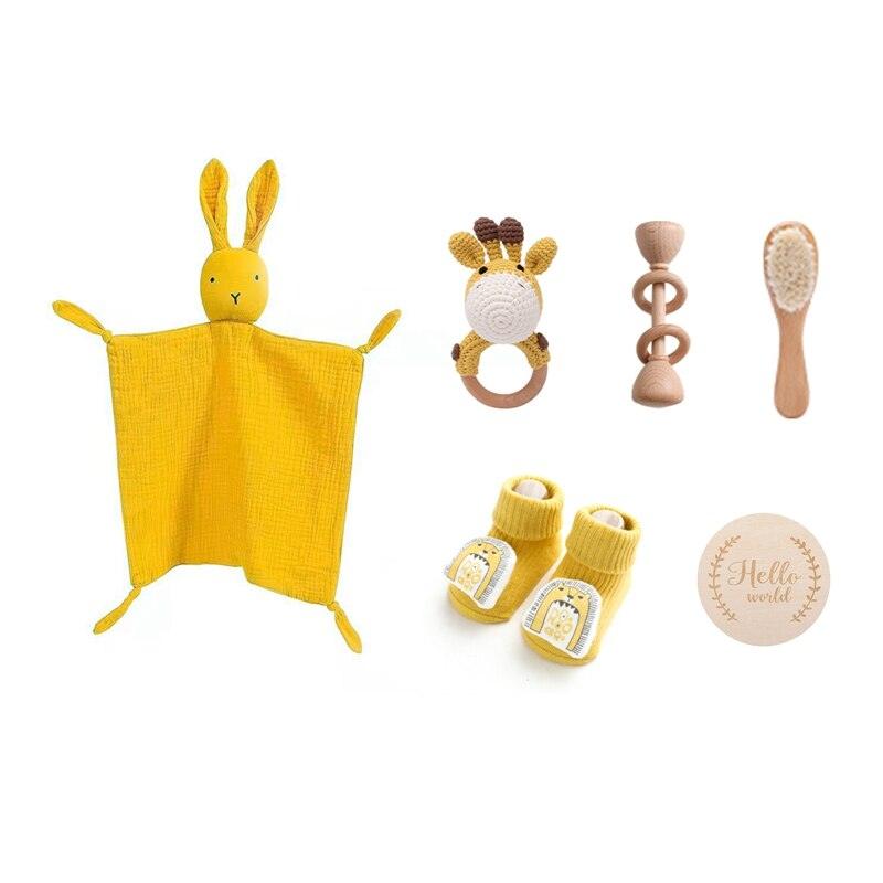 Das Shania Baby Geschenk zur Geburt von Hello World enthält eine Hasen-Lovey-Decke, einen Rasselgiraffe-Beißring, eine Holzrassel, eine Babybürste, gelbe Tiersocken und eine "Hello world"-Holzplakette - das nachhaltige Geschenk zur Geburt.