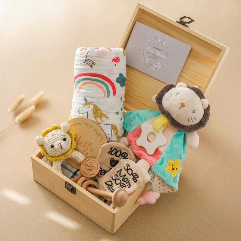 Die Jannis Baby Geschenk zur Geburt Holzbox von Hello World enthält Babydecke, Rassellöwe, Kuschelpuppe, gehäkelte Tier-Rassel, Holz-Meilenstein-Karten und Grußkarte - nachhaltig und liebevoll arrangiert.
