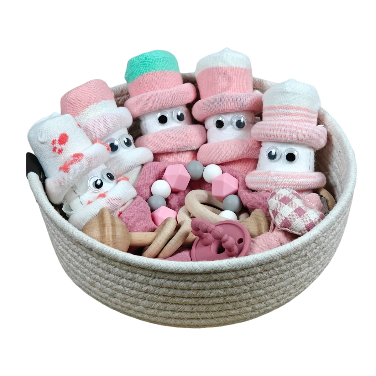 Das Hello World Kuschelkörbchen Blütenfünflinge besteht aus gerollten Babysöckchen mit Glotzaugen als niedliche Figuren, dazu rosa und hölzernes Babyspielzeug und natürliche Beißperlen.