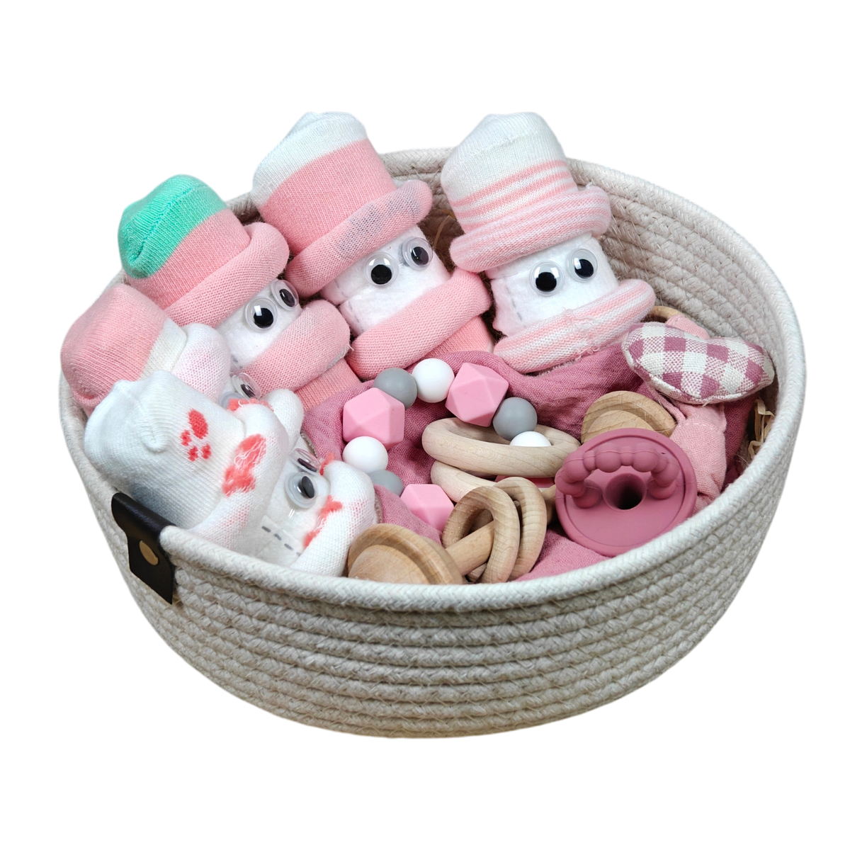 Der Geschenkkorb Hello World Kuschelkörbchen Blütenfünflinge enthält gerollte Babysocken mit Gesichtern, rosafarbene und weiße Accessoires, einen rosafarbenen Beißring und Holzspielzeug aus natürlichen Materialien - ein entzückendes Babygeschenk.