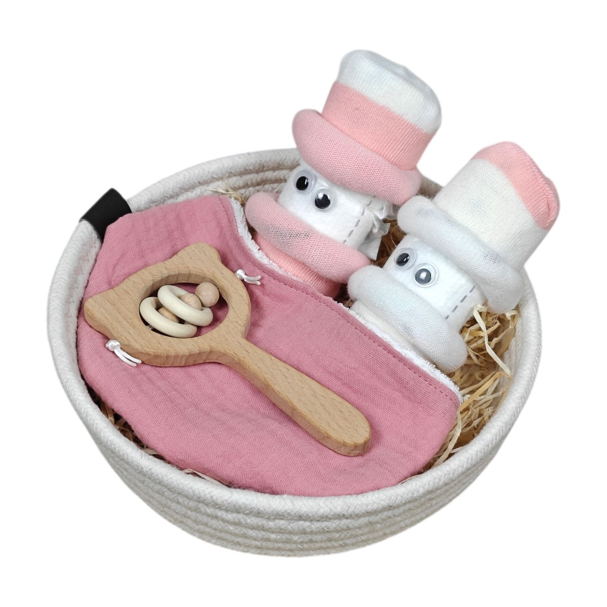 Das Kuschelkörbchen Blütenzwillinge von Hello World ist ein weißes Baby-Geschenkset mit einem rosa Lätzchen, einer Holzrassel mit weißen Ringen und zwei Paar Babysocken in Weiß und Rosa, die als kleine Gesichter mit Kulleraugen gestaltet sind.