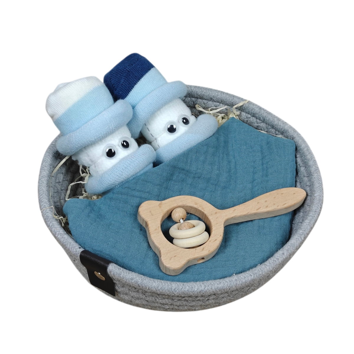 Das runde graue Kuschelkörbchen Wolkenzwillinge von Hello World enthält zwei Paar gerollte Babysocken, ein blaues Tuch und eine hölzerne Babyrassel mit Ringen auf strohartigem Füllmaterial - ein schönes Geschenk zur Geburt!.
