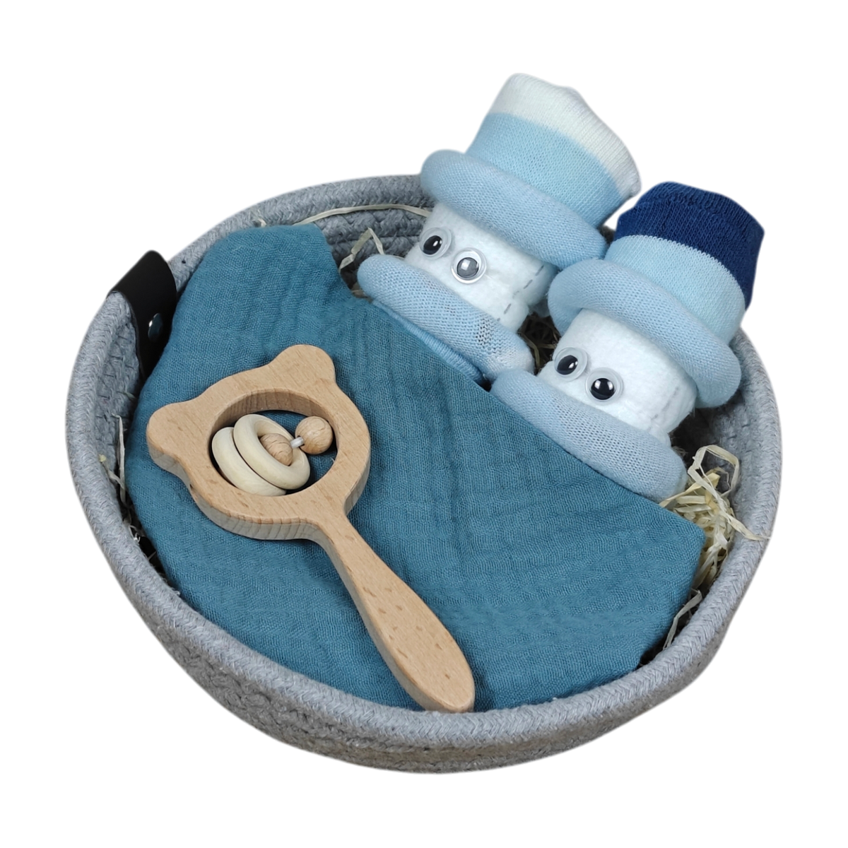 Das Kuschelkörbchen Wolkenzwillinge von Hello World ist ein runder Korb mit zwei gerollten Babysocken als Puppen mit Mützen, einem gefalteten blauen Tuch, Strohfüllung und einer hölzernen Bärenkopf-Rassel - ein ideales Geschenk für Neugeborene.