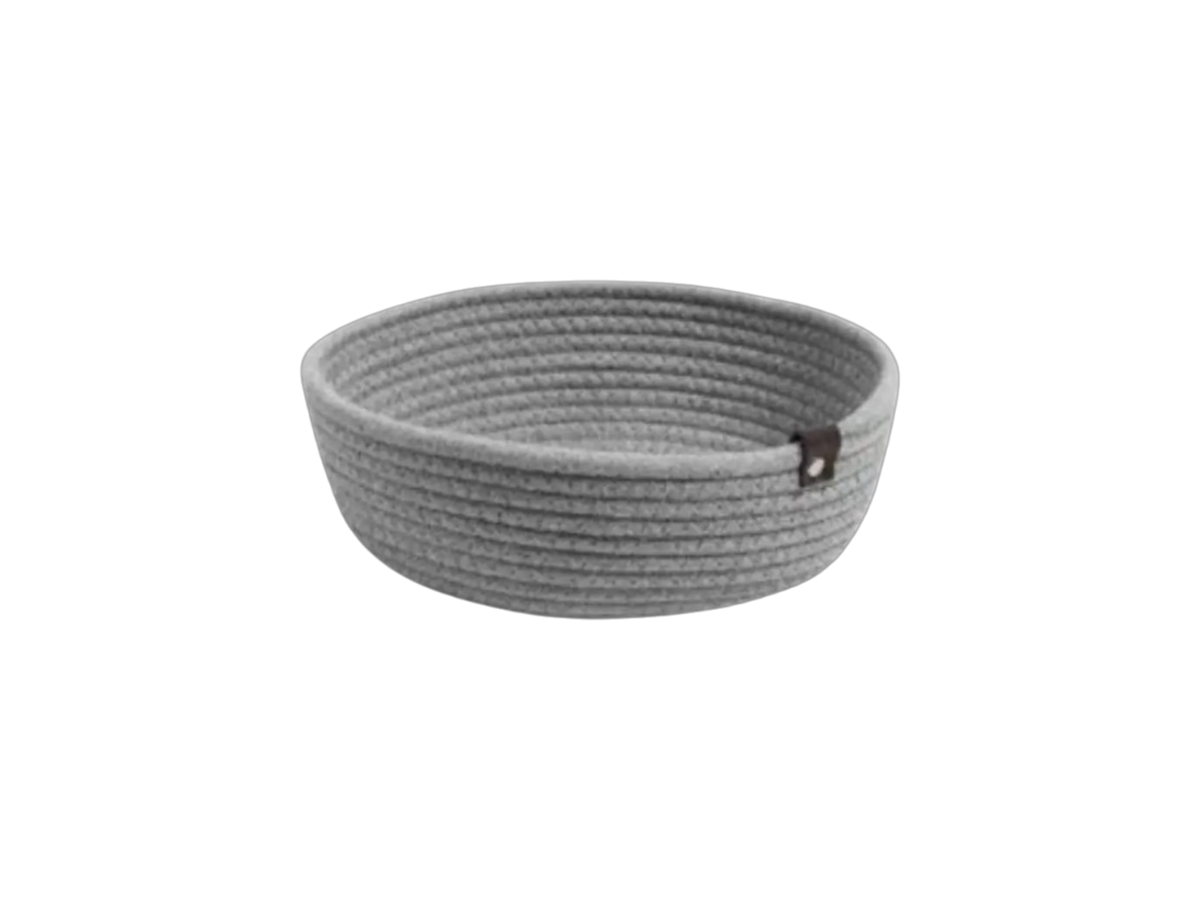 Das Kuschelkörbchen Regentropfen von Hello World ist ein runder, hellgrauer, geflochtener Seilkorb mit einem kleinen braunen Anhänger - perfekt als Geschenk zur Geburt - auf einem schlichten weißen Hintergrund.