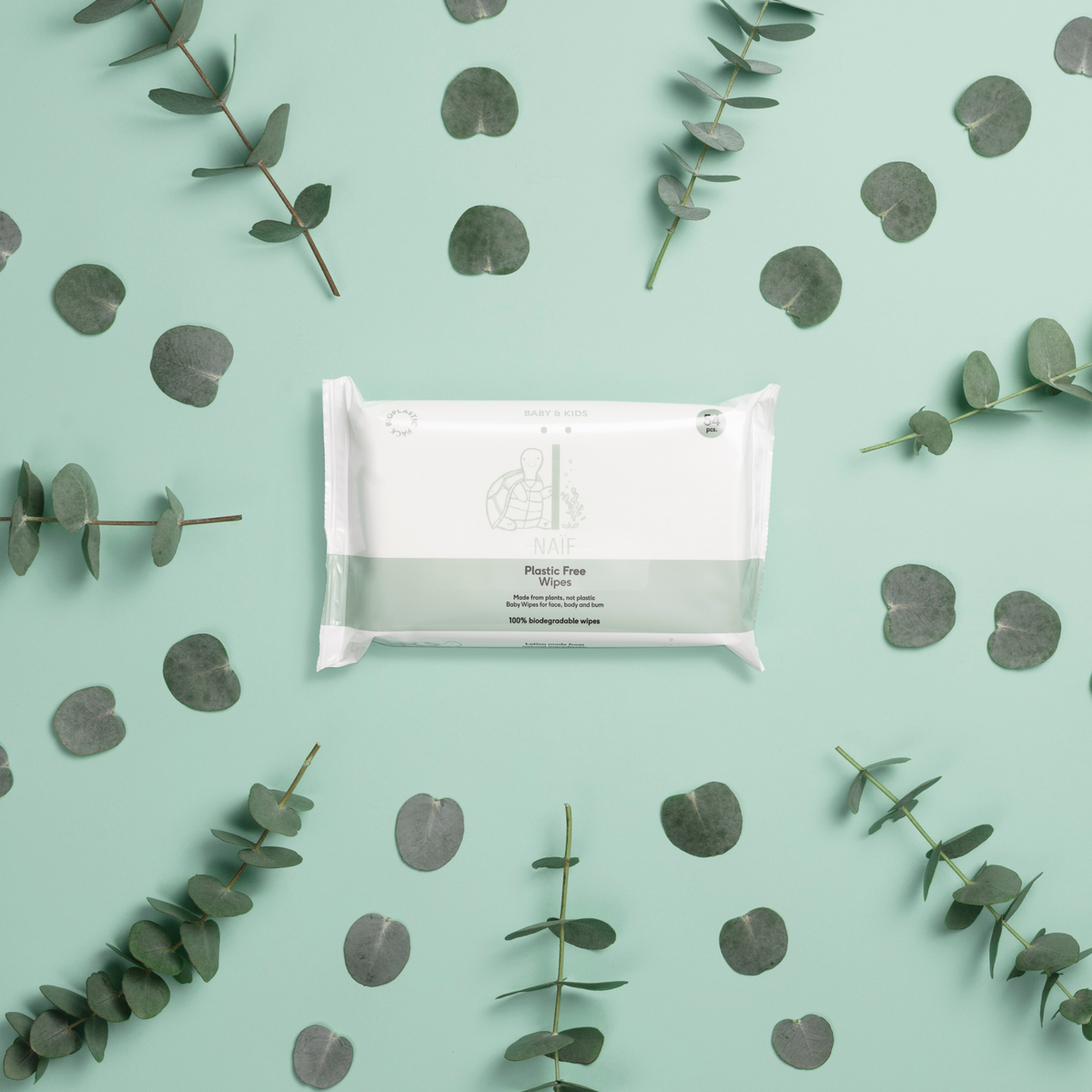 Naïf baby wipes 54 pieces on a mint background with eucalyptus branches - sustainable and plastic-free cleaning.