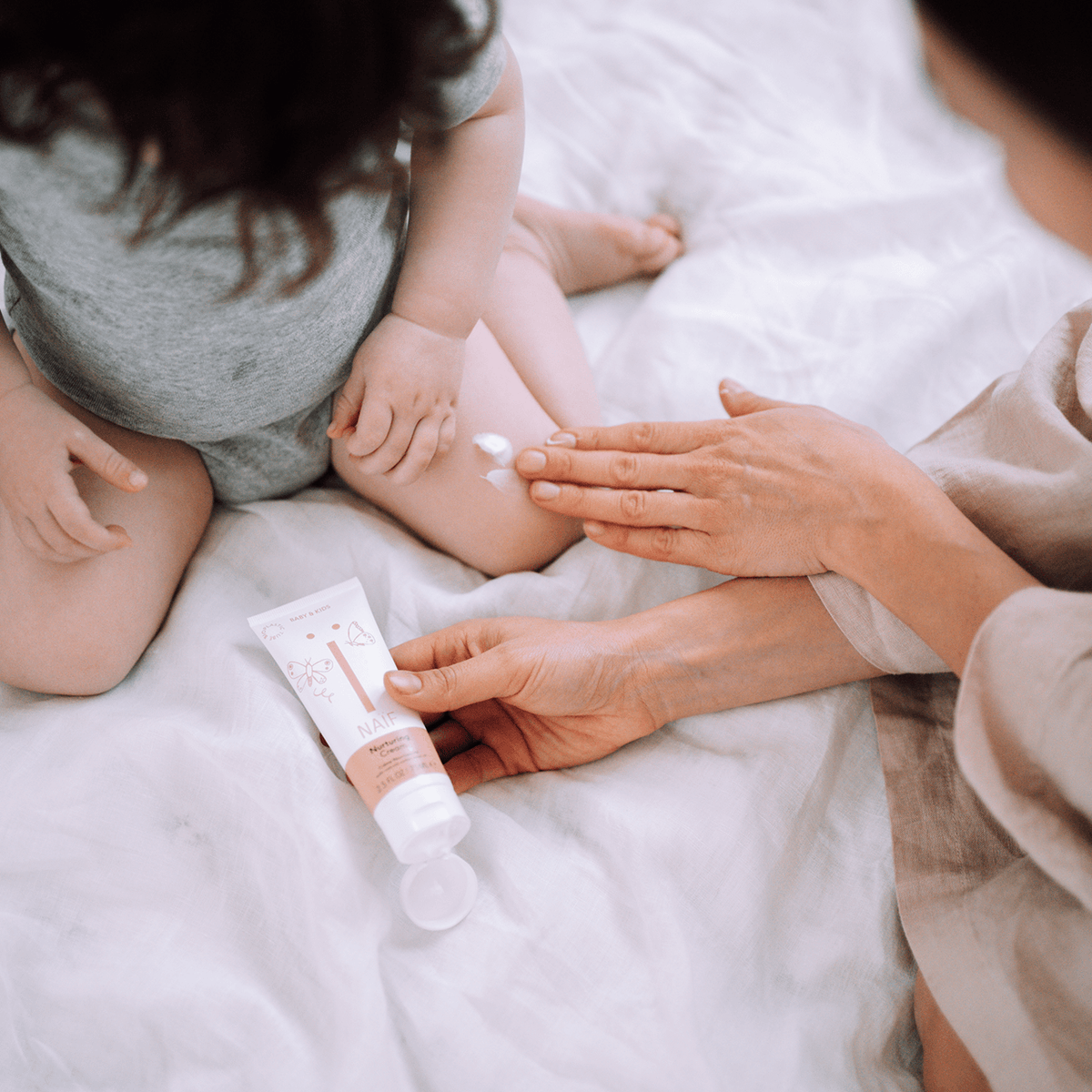 Naïf Baby & Kids Care Cream 75 ml is gently applied to a child's sensitive skin.