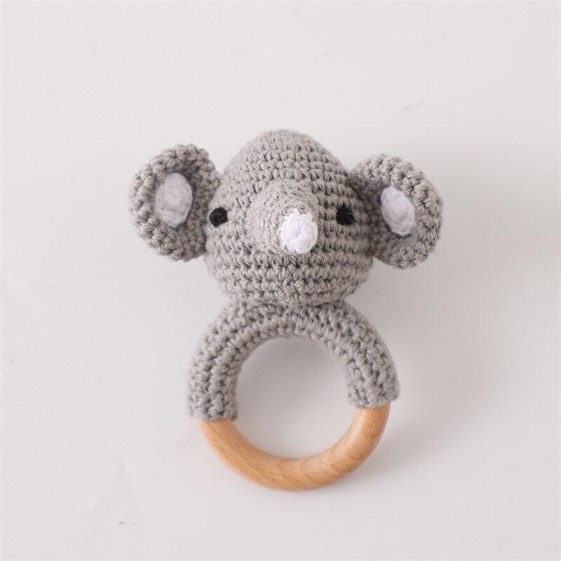 Das Hello World Ringo Baby Geschenk zur Geburt zeigt einen gehäkelten grauen Elefantenkopf mit großen Ohren auf einem hölzernen Ring, der als charmante Rassel oder Beißring dient.