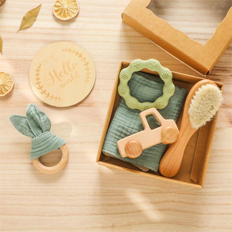 Das Silas Baby Geschenk zur Geburt von Hello World besteht aus einer grünen Decke, einem Holzauto, einer Bürste mit weichen Borsten, einem Holz-Greifling, einem grünen Silikon-Beißring, einer Hello World Holzscheibe und einem Hasenohr-Beißring - perfekt für Neugeborene.