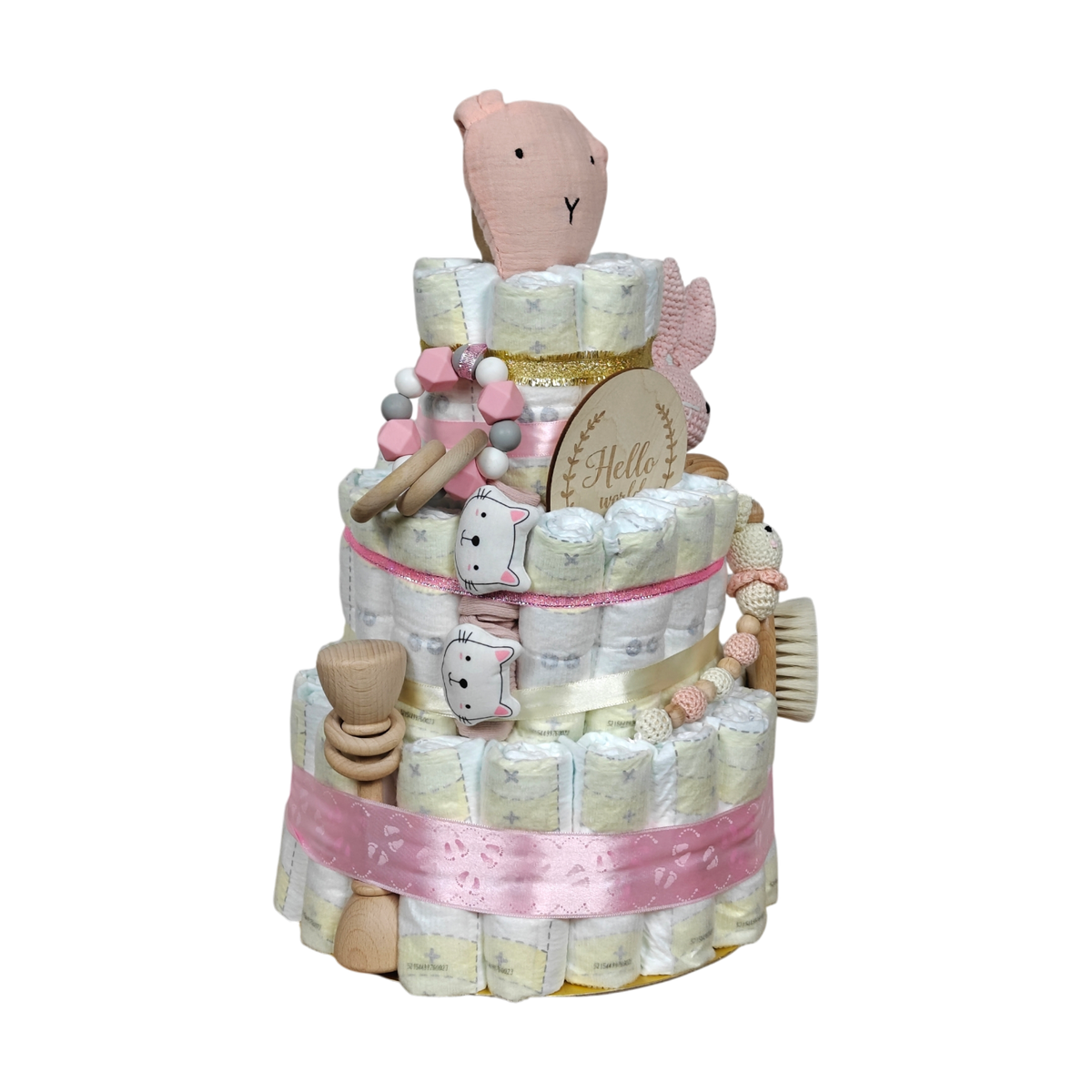 Die Windeltorte Schnuffel rosa von Hello World ist eine dreistöckige Windeltorte, die mit rosa Schleife, Babyzubehör aus Holz, Beißspielzeug und einem Plüschbären verziert ist - ideal als Babygeschenk oder als niedlicher Mittelpunkt einer Babyparty.