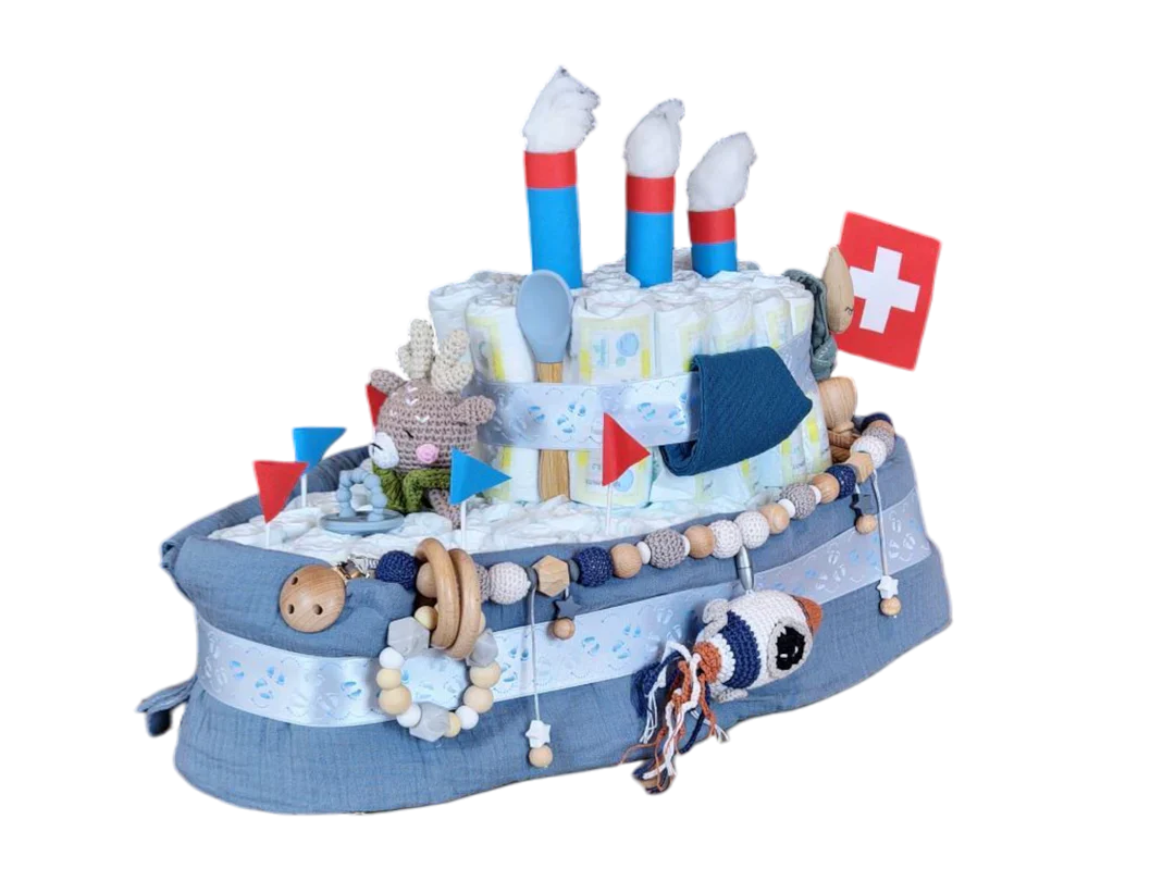 Eine Windeltorte in Form eines Schiffes, verziert mit kleinen Fähnchen, blauem Band, gehäkelten Tieren und einer Schweizer Flagge, wobei gerollte Windeln die Schornsteine des Schiffes bilden.