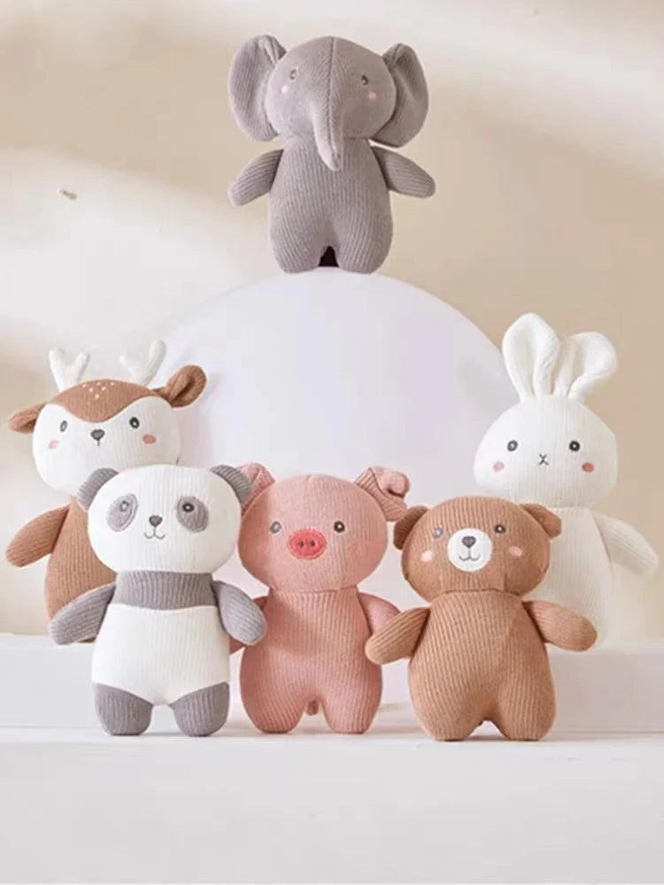 Sechs Plüschtiere, darunter ein Elefant, ein Hirsch, ein Kaninchen, ein Panda, ein Schwein und ein Bär, sind in zwei Reihen vor einem hellen Hintergrund mit sanfter Beleuchtung angeordnet.