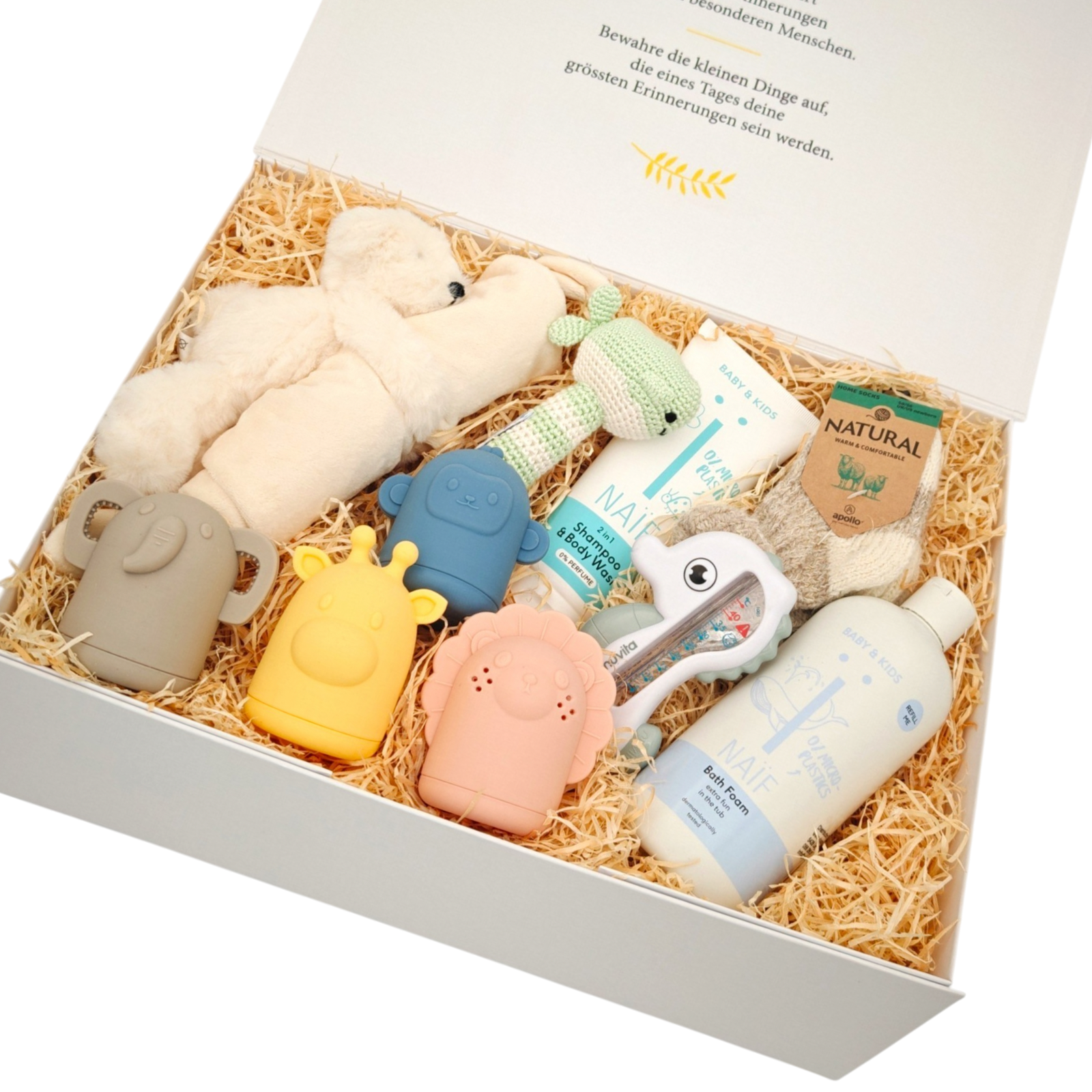 Premium Baby Geschenkbox Yuna in Schrägansicht mit NAÏF Pflegeprodukten, Kuscheltier, buntem Silikonspielzeug und gehäkelter Rassel, liebevoll auf Holzwolle arrangiert.