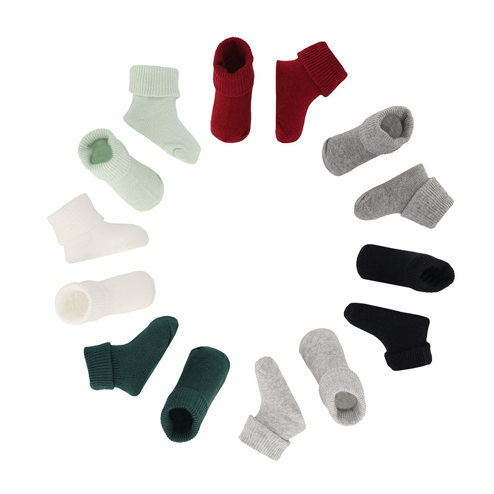 Sieben Paar Baumwollsocken für Babys kreisförmig in verschiedenen Jungenfarben angeordnet