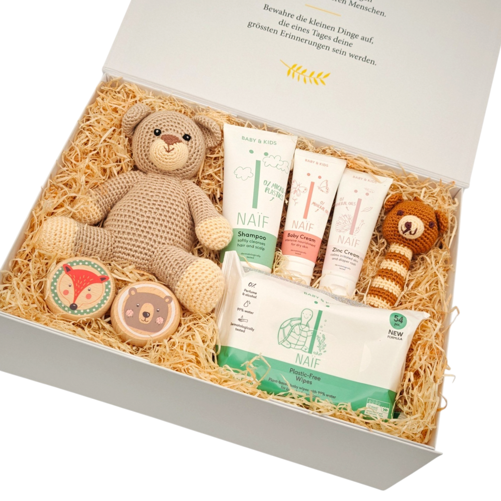 Geschenkbox Bruno in Schrägansicht mit gehäkeltem Kuschelbär, NAÏF Babypflege, Babydecke, Schnuller und weiteren liebevoll ausgewählten Babygeschenken in einer hochwertigen Magnetbox.