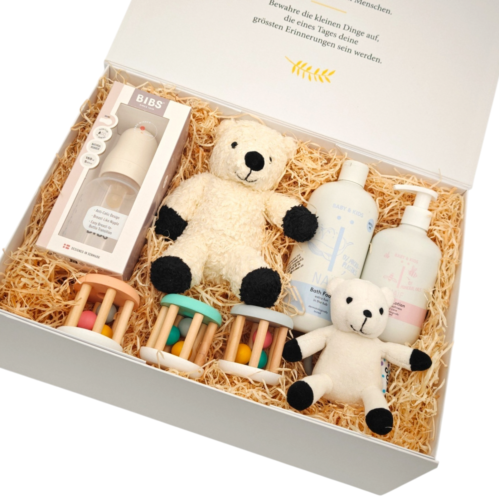 Geschenkbox Emil in Schrägansicht mit weichem Kuschelschaf, passendem Schäfchen, BIBS Babyflasche, Babypflege und bunten Holzrasseln in einer hochwertigen Magnetbox.