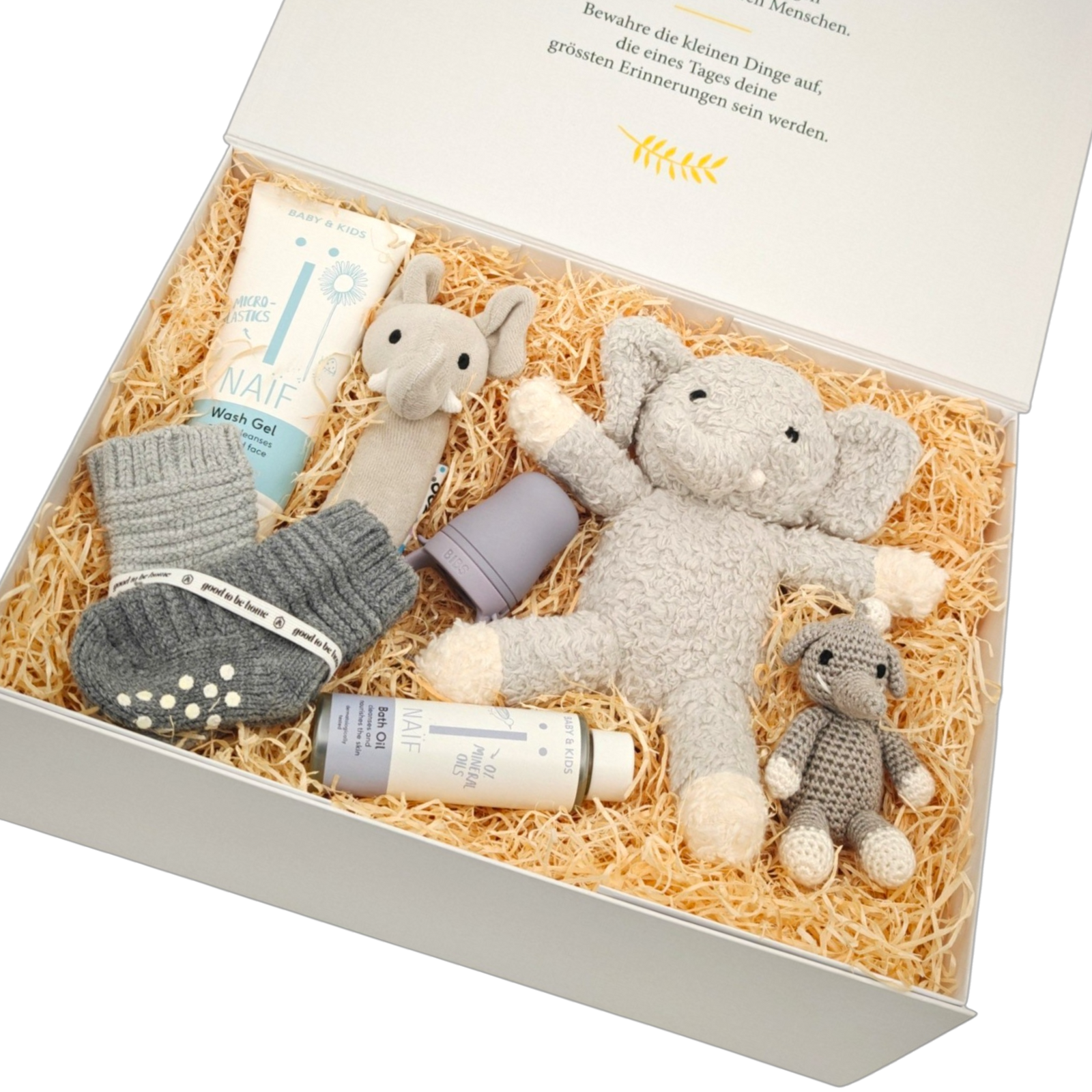 Geschenkbox Julian in Schrägansicht mit weichem Elefanten-Kuscheltier, gehäkelter Elefantenrassel, NAÏF Babypflege und grauen Babysöckchen in einer hochwertigen Magnetbox.