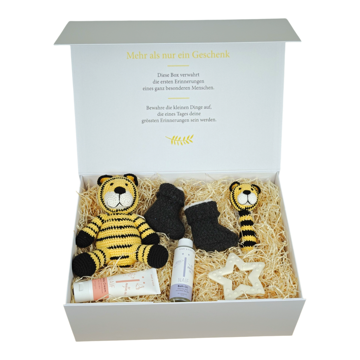 Geschenkbox Leandro für Babys mit gehäkeltem Tiger, passender Babyrassel, gestrickten Babyschuhen, BIBS Beissring Stern, NAÏF Badeöl und Babycreme in cremeweisser Magnetbox.