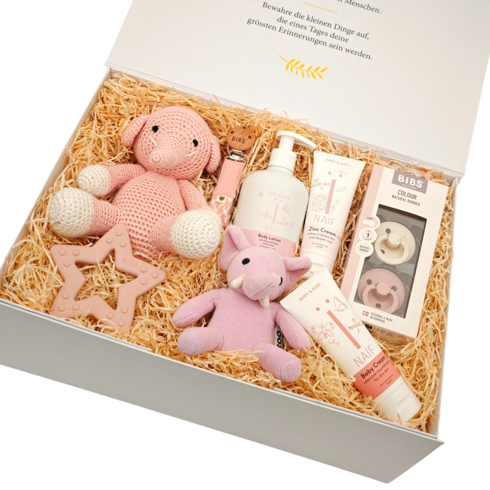 Geschenkbox Leni in Schrägansicht mit rosa gehäkeltem Kuscheltier, Elefantenrassel, BIBS Schnullern, NAÏF Babypflege und Holzstern in einer hochwertigen Magnetbox.
