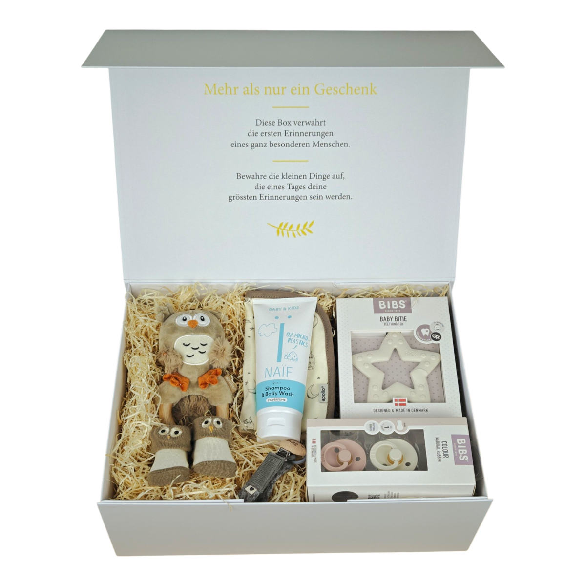 Coffret Lio pour bébé beige, marron et gris comprenant un hochet chouette, un bavoir, des chaussettes bébé, des tétines BIBS, un attache-sucette, un anneau de dentition étoile et un shampoing & gel douche NAÏF 2en1 dans une boîte magnétique blanc crème.