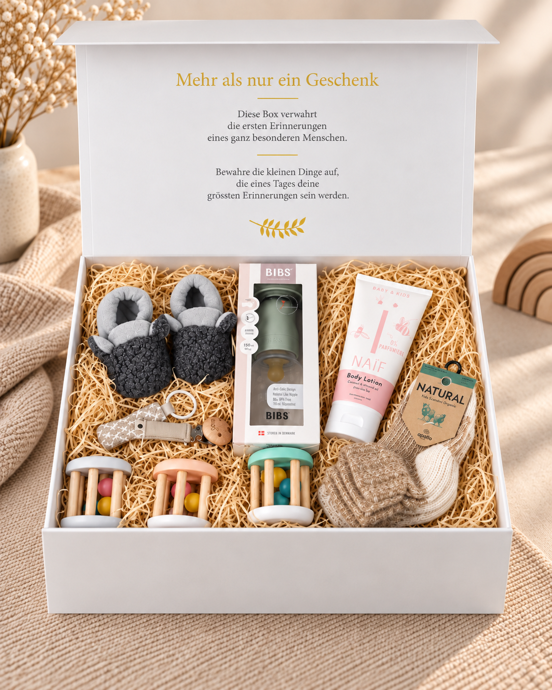Offene Baby Geschenkbox Mika mit BIBS Babyflasche Grün, Schnullerkette, Holz-Greifspielzeug, grauen Babyschuhen, Wollsocken und NAÏF Bodylotion