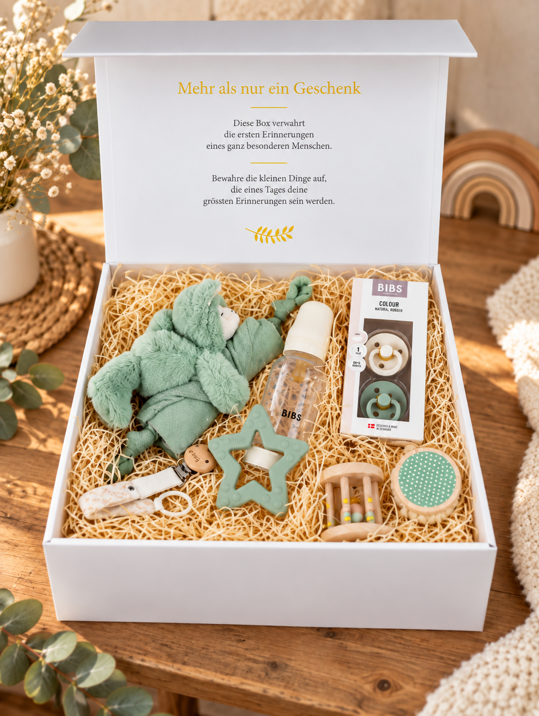 Coffret cadeau bébé ouvert Mira avec doudou vert lama, crème pour biberon BIBS, lot de 2 tétines, chaîne de tétine, anneau de dentition étoile et jouet de préhension