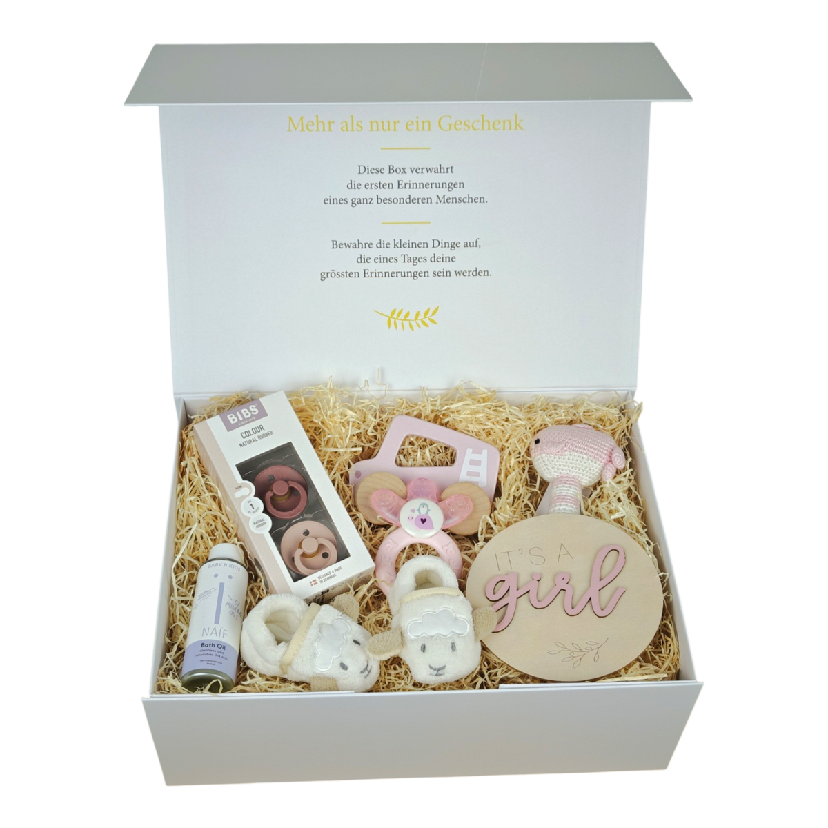 Tiffany gift box for babies in pink and cream with BIBS pacifiers, crocheted whale rattle, sheep baby shoes, pink push car, cooling teething ring, NAÏF bath oil and wooden sign “It’s a girl” in a cream white magnetic box.