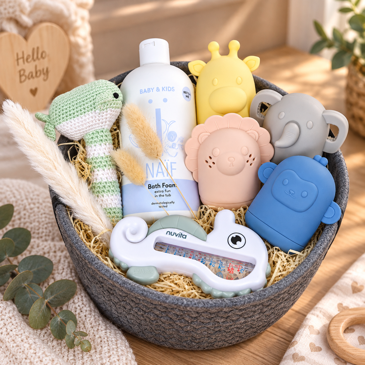 Grauer Baby Geschenkkorb mit NAÏF Badepflege, gehäkeltem Wal, tierischen Bade- und Spielartikeln sowie Nuvita Badethermometer als liebevolles Geschenk zur Geburt.