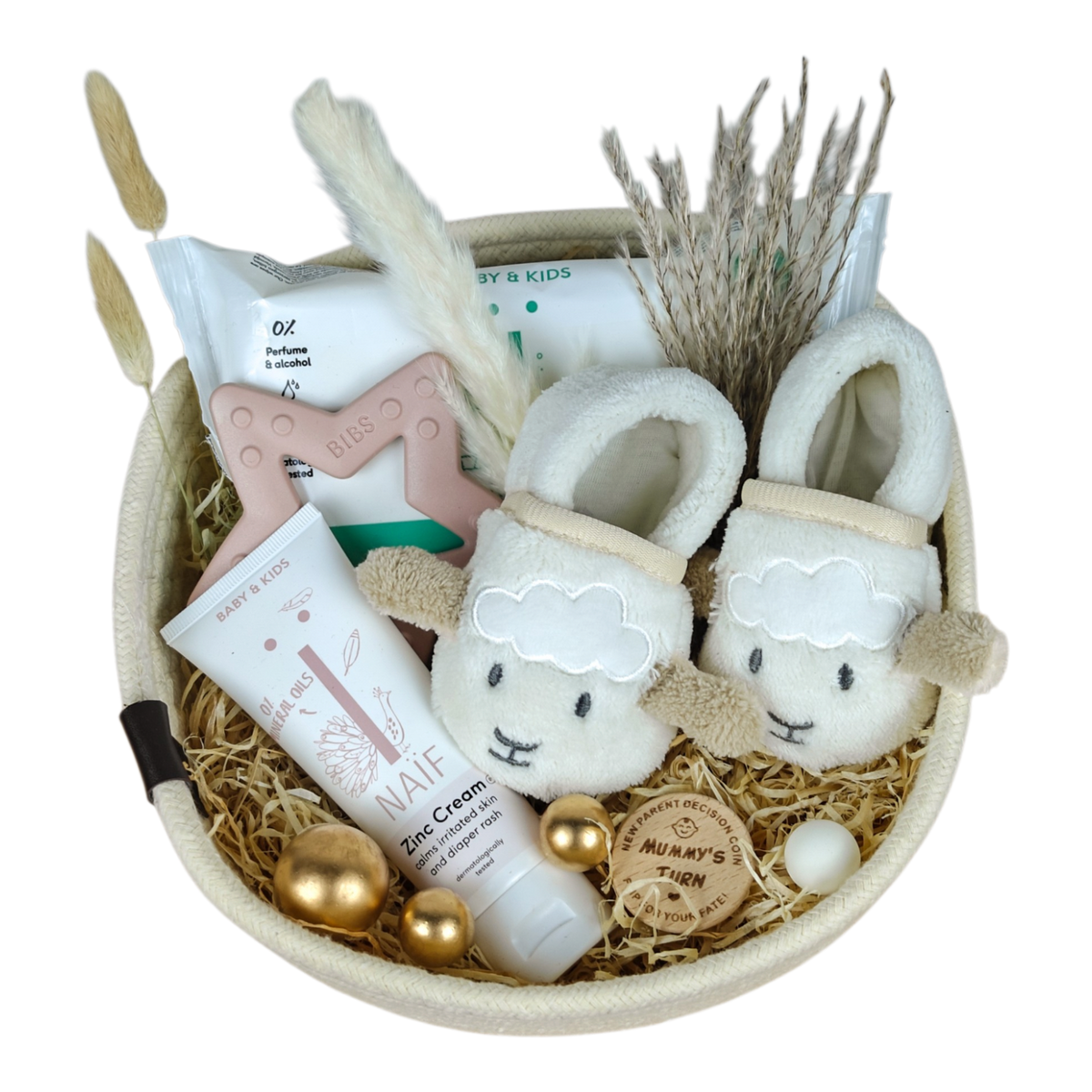 Panier cadeau bébé Elian dans un panier en coton blanc avec chaussons bébé mouton, anneau de dentition BIBS rose, soin NAÏF et pièce en bois