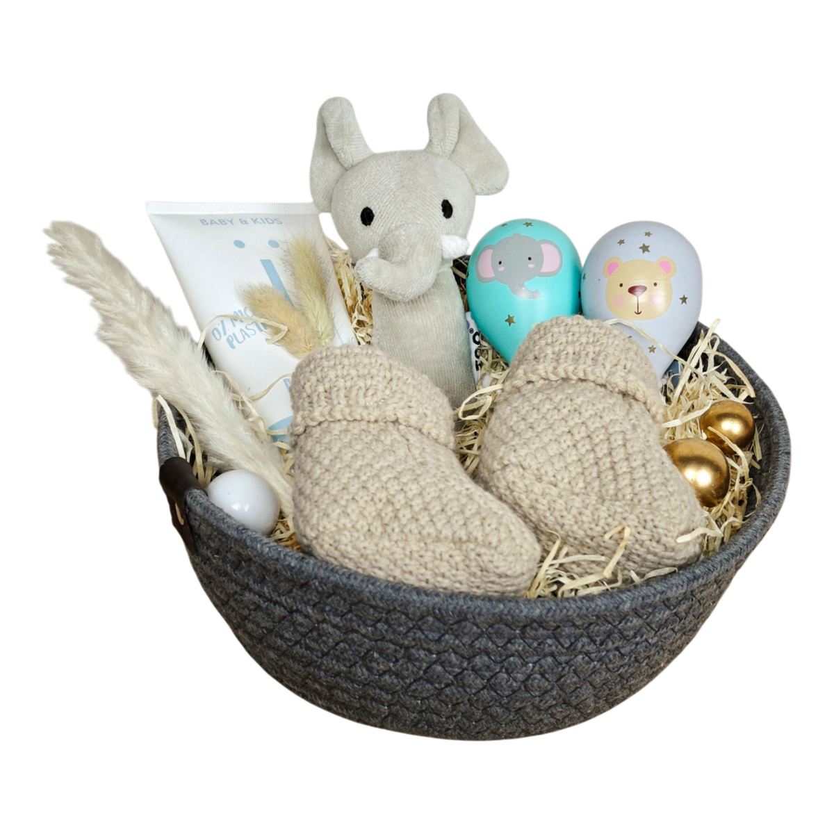 Baby Geschenkkorb in Naturtönen mit Kuscheltier, gestrickten Babyschuhen, Pflegeprodukt und Babyspielzeug.