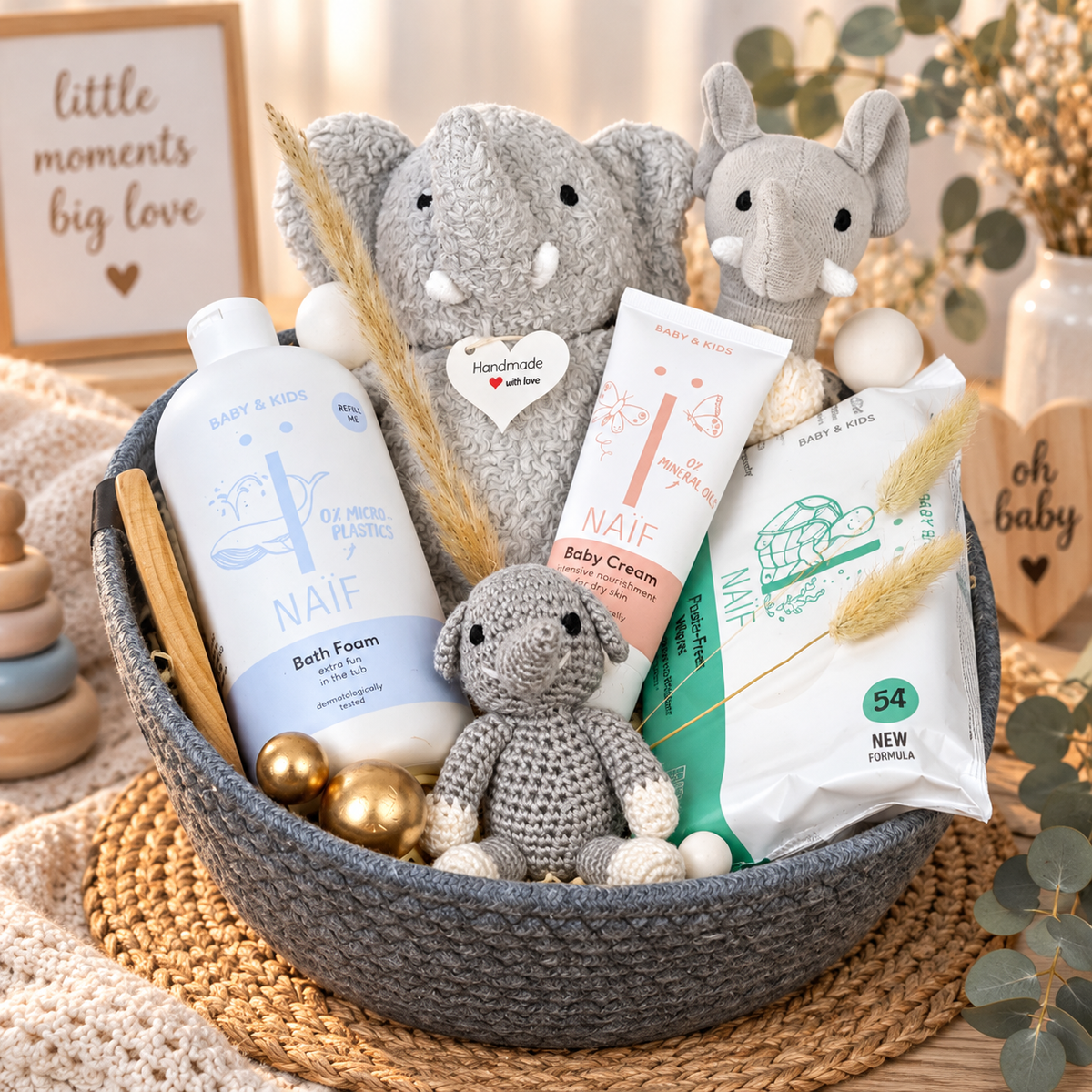 Geschenkkorb Luan als hochwertiges Babygeschenk mit Elefanten, NAÏF Babypflege, Feuchttüchern, Holzpflegezubehör und liebevollen Details in Grau, Creme und Naturtönen.