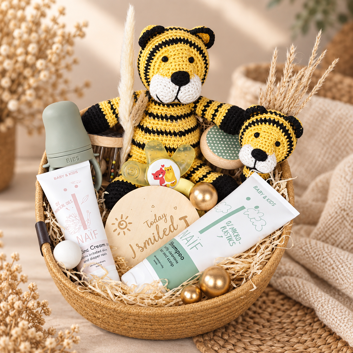 Liebevoll arrangierter Geschenkkorb Tiger für Babys mit gehäkeltem Tiger, BIBS Babyflasche, NAÏF Pflegeprodukten, Schnuller und Babyspielzeug