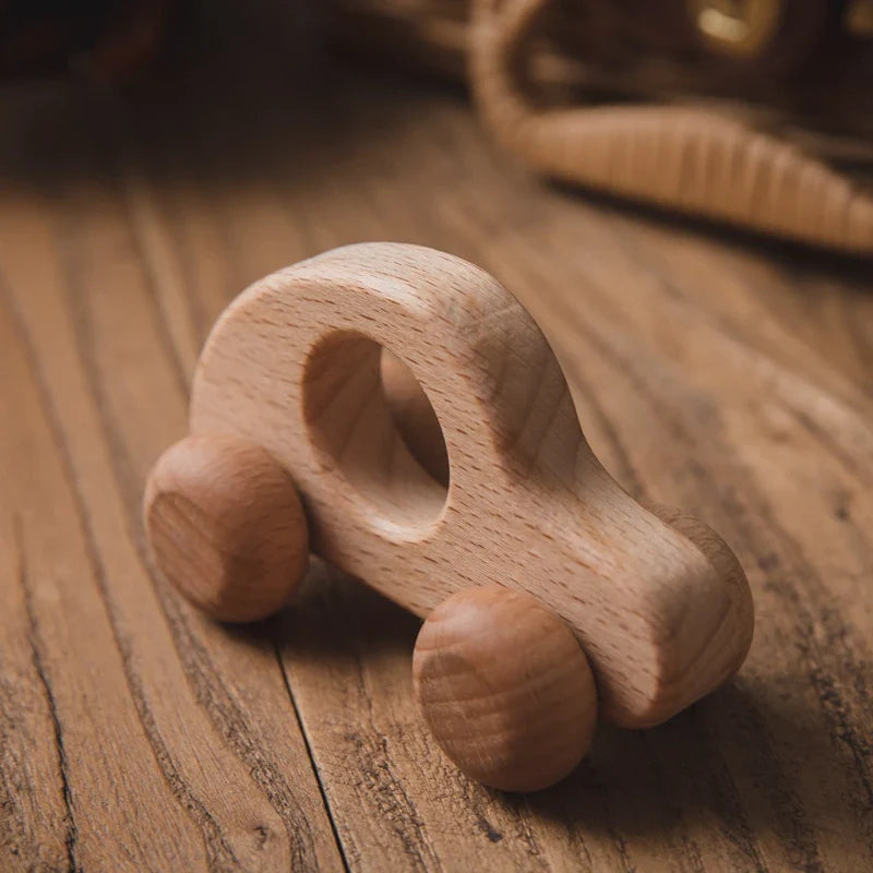 Das Hello World Auto Rund aus Holz [8,5x4cm] ist ein kleines, glattes Holzspielzeugauto mit abgerundeten Kanten, einer Aussparung in der Mitte, vier einfachen Rädern und einer natürlichen Holzoberfläche - perfekt als nachhaltiges Spielzeug.