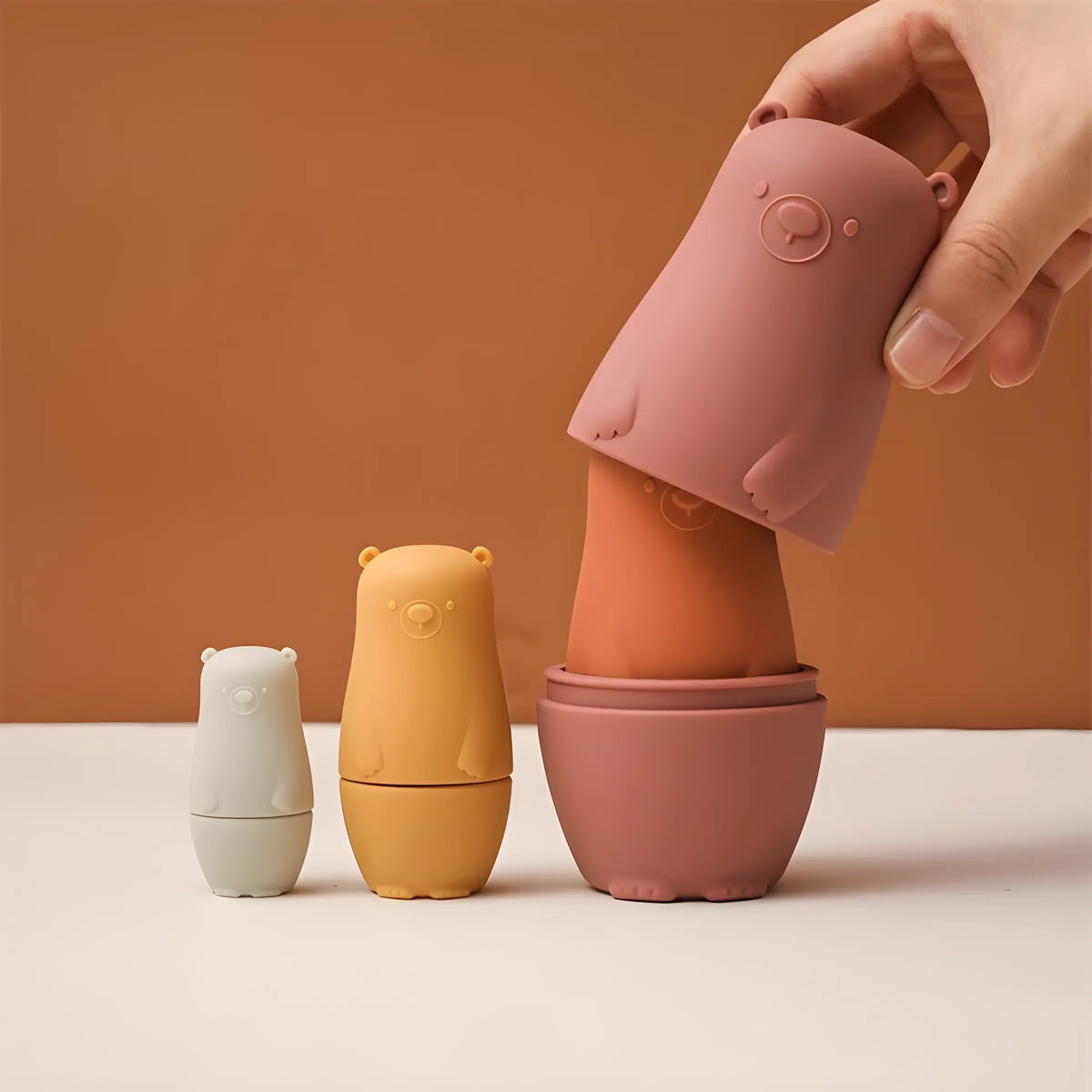 Der Bär Rot aus Silikon [6x13cm] von Hello World lässt sich aufklappen und offenbart einen kleineren Bären im Inneren. Dieses charmante Spielzeug eignet sich sowohl als spielerischer Lernspaß für Kinder als auch als niedliches Dekostück.