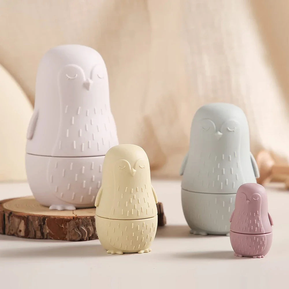 Das Hello World Pinguin Beige aus Silikon [7x12cm] zeigt ein bezauberndes, eulenförmiges Design in Pastelltönen, angeordnet auf einer neutralen Oberfläche mit einem weichen beigen Hintergrund - perfekt für eine stilvolle und verspielte Dekoration.