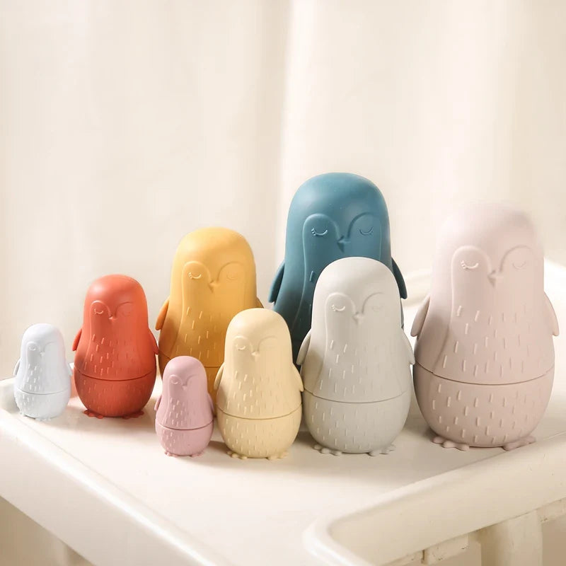 Das Hello World Pinguin Beige aus Silikon [7x12cm] zeigt ein verspieltes, von Pinguinen inspiriertes Design in neutralen Tönen, das auf einer weißen Fläche vor einem schlichten Hintergrund angeordnet ist.