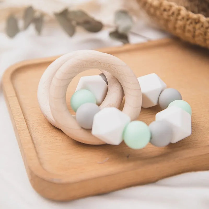 Die Hello World Beissring Kette Duo Mintgrün [7x9cm] besteht aus zwei ineinandergreifenden Holzringen und zarten pastellfarbenen Perlen - ideal als süße Zahnungshilfe Baby oder Ergänzung zur Beissring-Kette.