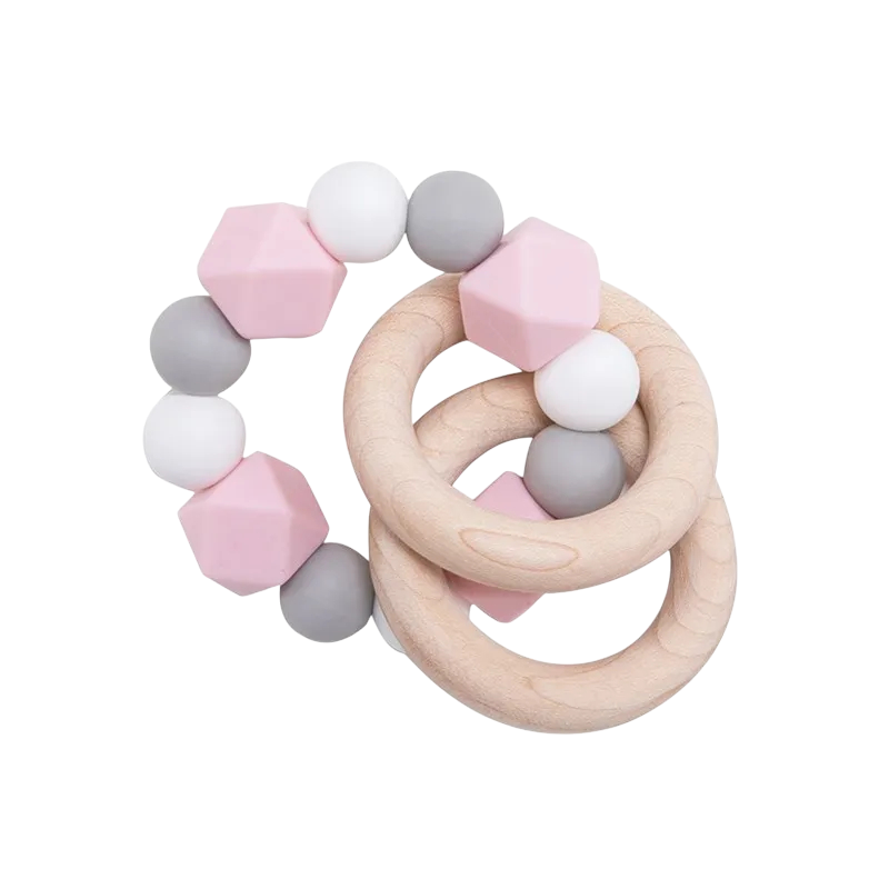 Die Hello World Beissring Kette Duo Rosa [7x9cm] besteht aus zwei natürlichen Holzringen, die durch rosa, graue und weiße Silikonperlen verbunden sind. Dieses stilvolle Baby-Beißspielzeug ist die ideale Zahnungshilfe zur Beruhigung des wunden Zahnfleisches. Abgebildet auf weißem Hintergrund.