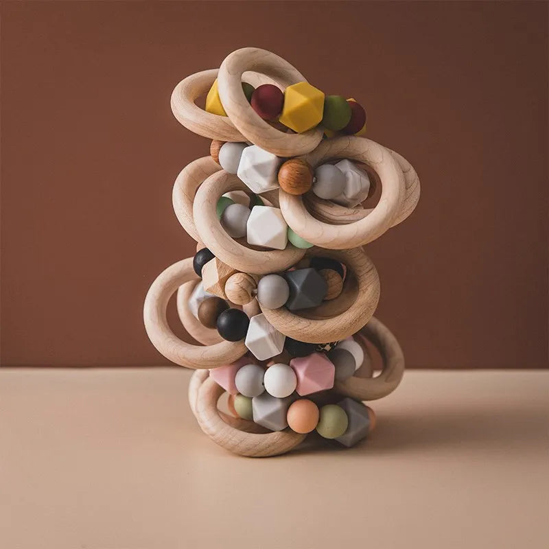 Die Beissring Kette Duo Rosa [7x9cm] von Hello World mit Holzringen und bunten Silikonperlen in geometrischem Design ist das perfekte Zahnungshilfe-Baby-Accessoire zur Linderung von Zahnungsbeschwerden.