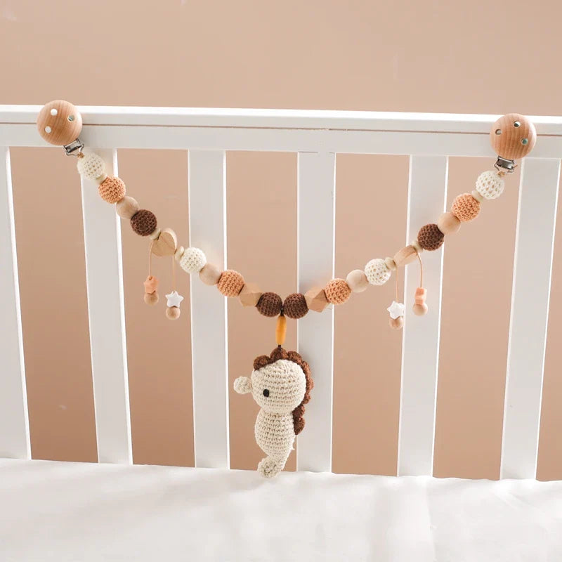 Die Hello World Kinderwagenkette Seepferdchen [30x35cm] besteht aus gehäkelten beigen, braunen und cremefarbenen Perlen mit einem Seepferdchen-Spielzeug, das sich perfekt über einem weißen Kinderbett drapieren und mit anderer Kinderzimmerdekoration zum Thema Meer kombinieren lässt.