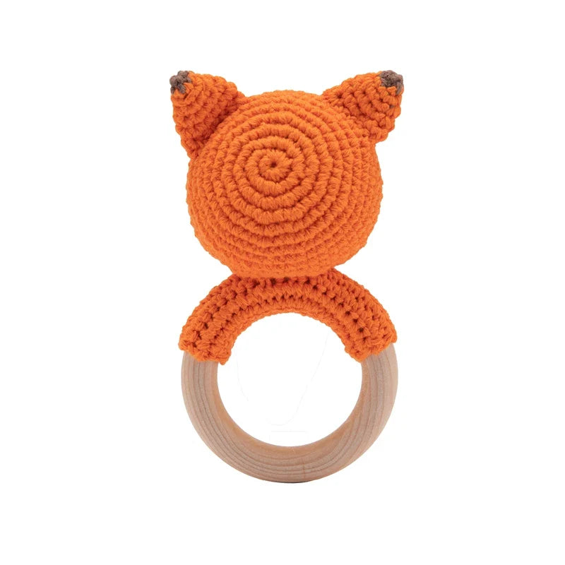 Das Rasseltier Fuchs [6.5x12cm] von Hello World ist ein handgefertigtes Spielzeug mit orangefarbenem, gehäkeltem Kopf an einem Holzring - perfekt als musikalisches Geschenk für Kinder und ideal zum Greifen.