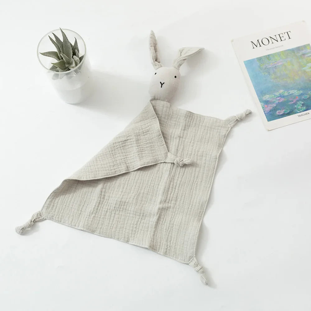 Der Schnuffel Grau [33x46cm] von Hello World - eine weiche, hellgraue Musselin-Bettdecke mit plüschigem Hasenkopf und geknoteten Ecken - verleiht jedem Kinderzimmer zeitlose Eleganz.