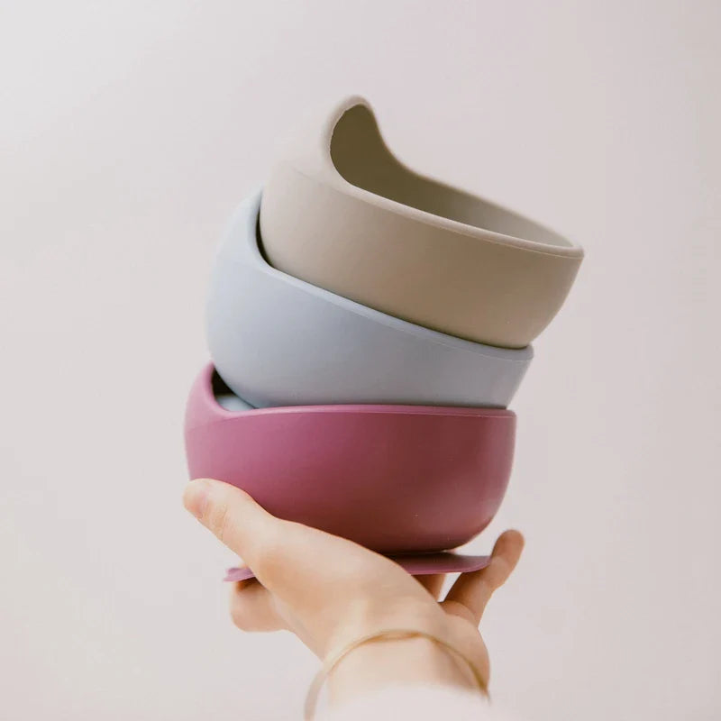 Eine Hand hält drei gestapelte Hello World Schüsseln rund Grau [12x8cm] vor einem schlichten hellen Hintergrund.