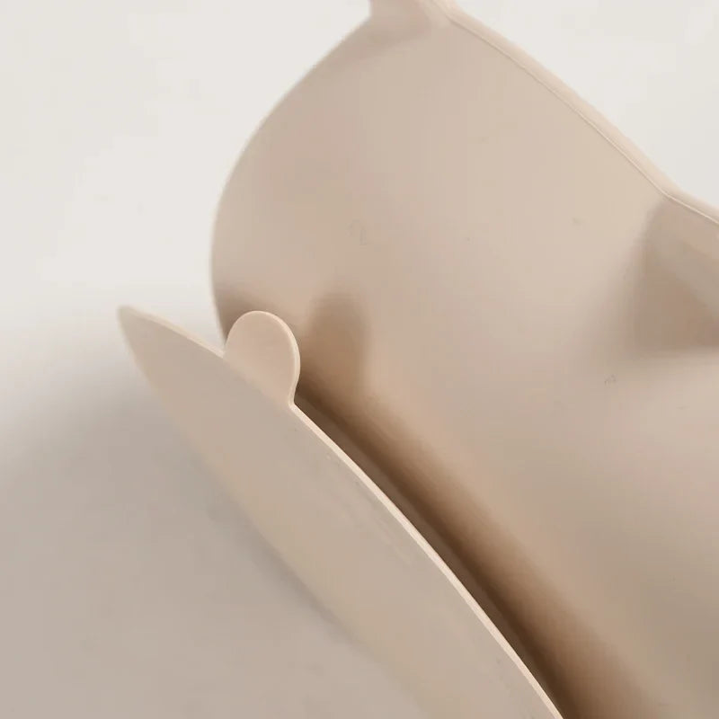 Nahaufnahme der beigefarbenen "Schüssel rund Katze" [12x5cm] von Hello World, die den geschwungenen Rand und die kleine abgerundete Lasche vor einem hellen Hintergrund zeigt.