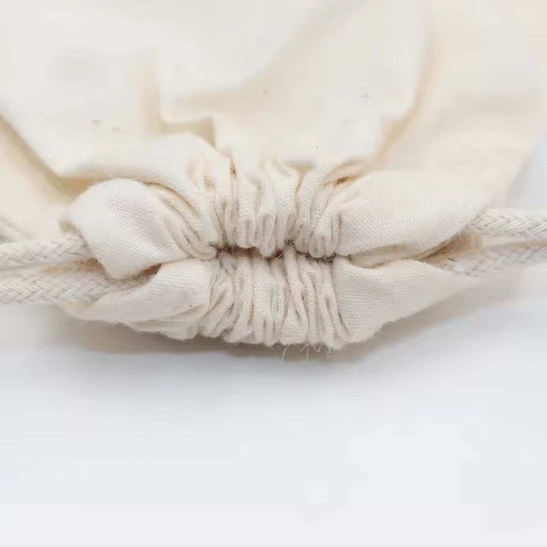 Nahaufnahme des Kordelzugverschlusses des Hello World Spielzeugbeutels (14,5 x 23,5 cm) von Hello World, mit gerafftem Stoff und weißer Kordel - ideal als Hello World Beutel oder Geschenk zur Geburt.