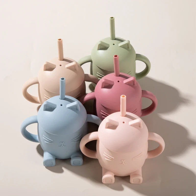 Fünf pastellfarbene Hello World Trinkbecher Katze sitzend Rosa [13x11cm] mit Strohhalm und Henkel sind auf einer hellen Fläche angeordnet und zeigen jeweils ein einfaches Katzenmotiv in Grün, Rosa, Blau, Creme und Beige.