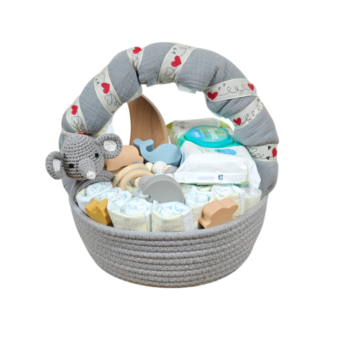 Das Hello World Windelgeschenk Körbchen (32x28cm) ist ein graues, gewebtes Babykörbchen, das mit Windeln, Feuchttüchern, einem gehäkelten Elefanten, Holzspielzeug, Schnuller und Pflegeprodukten gefüllt ist. Der gepolsterte Henkel ist mit einem Stoff mit Herzmuster überzogen.